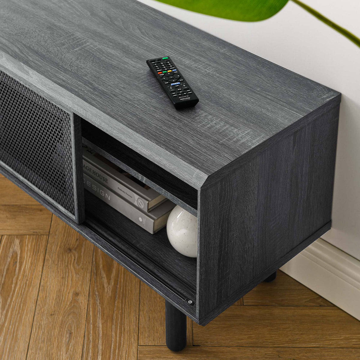 Charcoal TV stand styled with books and decor, emphasizing wood grain top and open shelf storage || EEI-6233-CHA || detail_room
