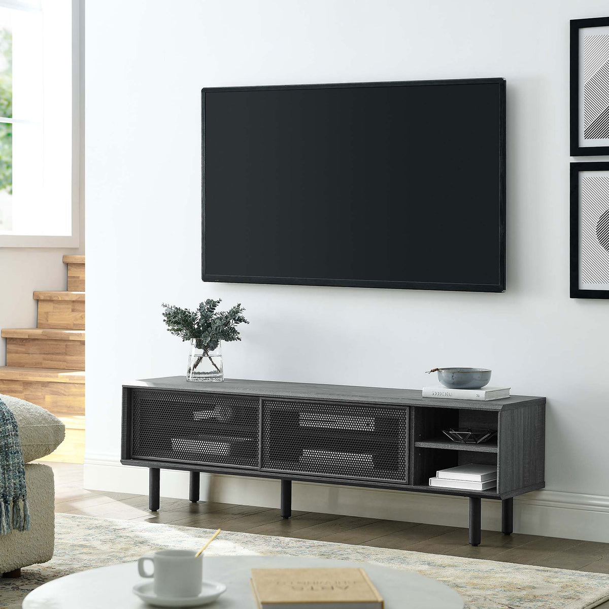 Kurtis 60 in charcoal TV stand in a modern living room beneath a wall-mounted television || EEI-6234-CHA || front_angle_room