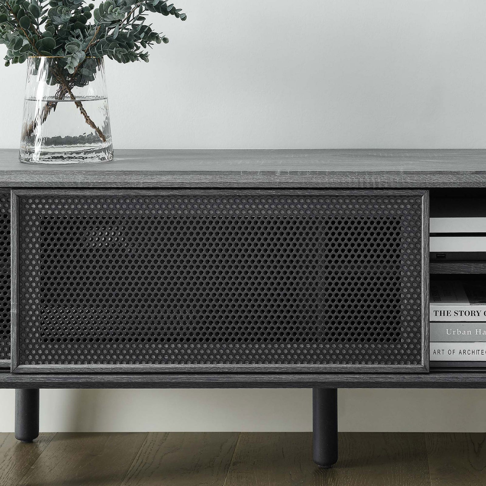 Styled charcoal TV stand topped with vase and books, highlighting textured mesh door and open shelf || EEI-6234-CHA || detail_room