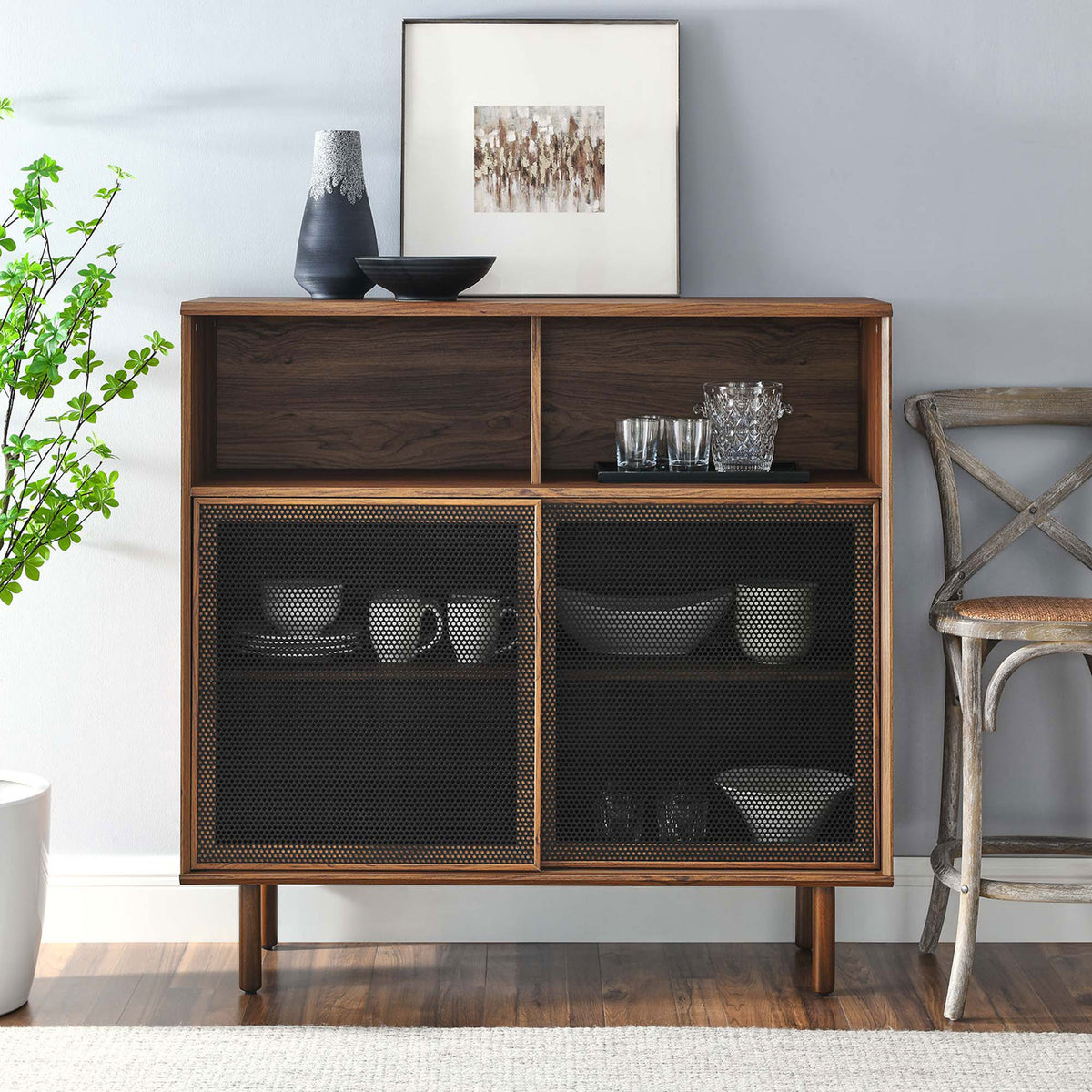 Walnut display cabinet styled with dishes, glassware, and art, enriching the room with chic industrial warmth. || EEI-6237-WAL || front_room