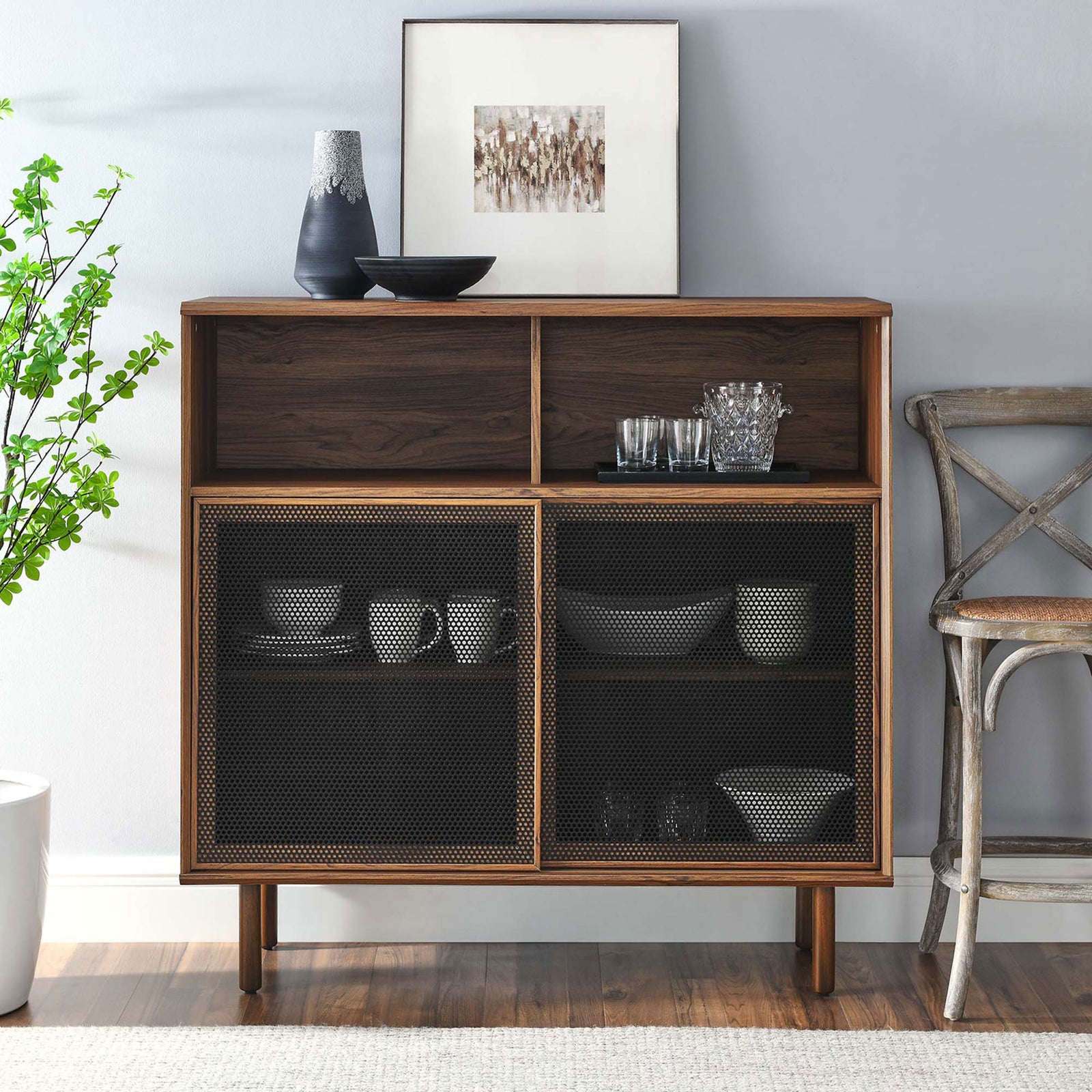 Walnut display cabinet styled with dishes, glassware, and art, enriching the room with chic industrial warmth. || EEI-6237-WAL || front_room