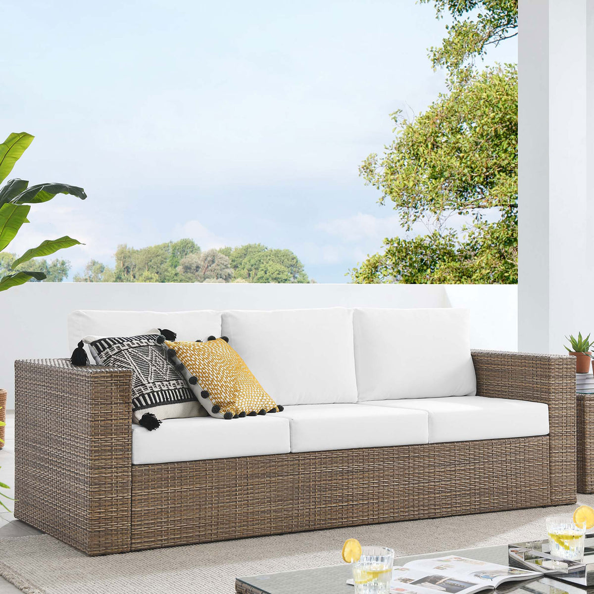 Convene outdoor sofa arranged on a modern patio, offering roomy three-seat comfort with white cushioned support. || EEI-6245-CAP-WHI || front_angle_room