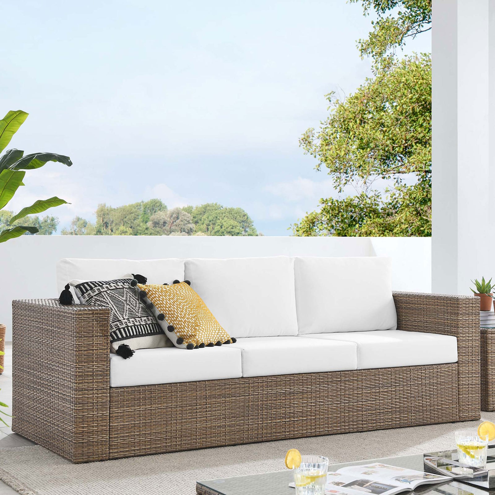 Convene outdoor sofa arranged on a modern patio, offering roomy three-seat comfort with white cushioned support. || EEI-6245-CAP-WHI || front_angle_room