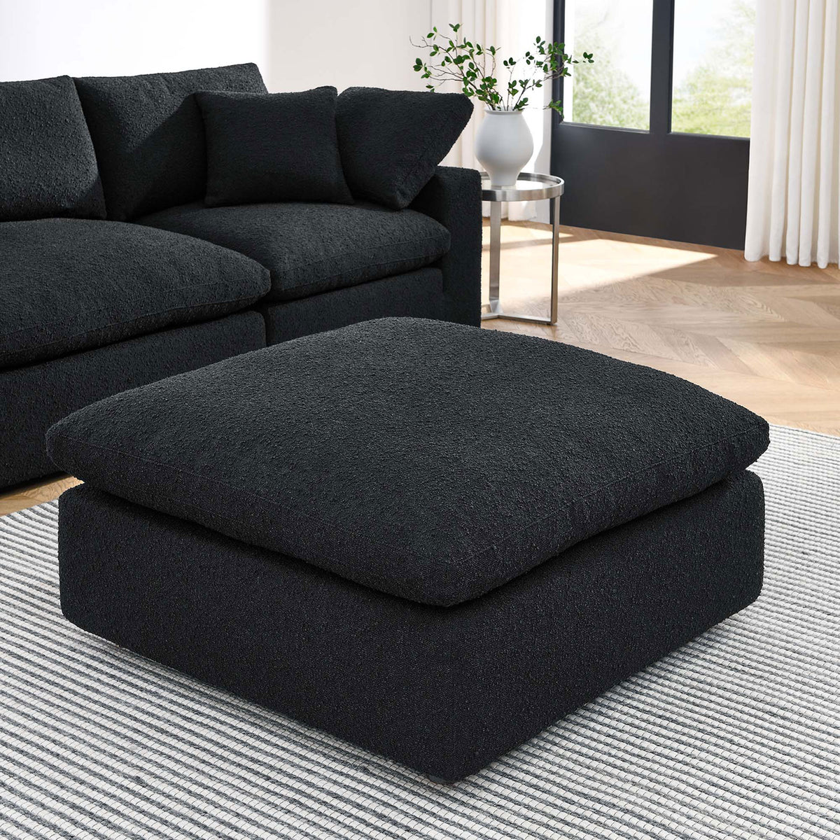 Plush black boucle ottoman adds extra lounge-ready seating to a contemporary living room sectional || EEI-6258-BLK || front_angle_room