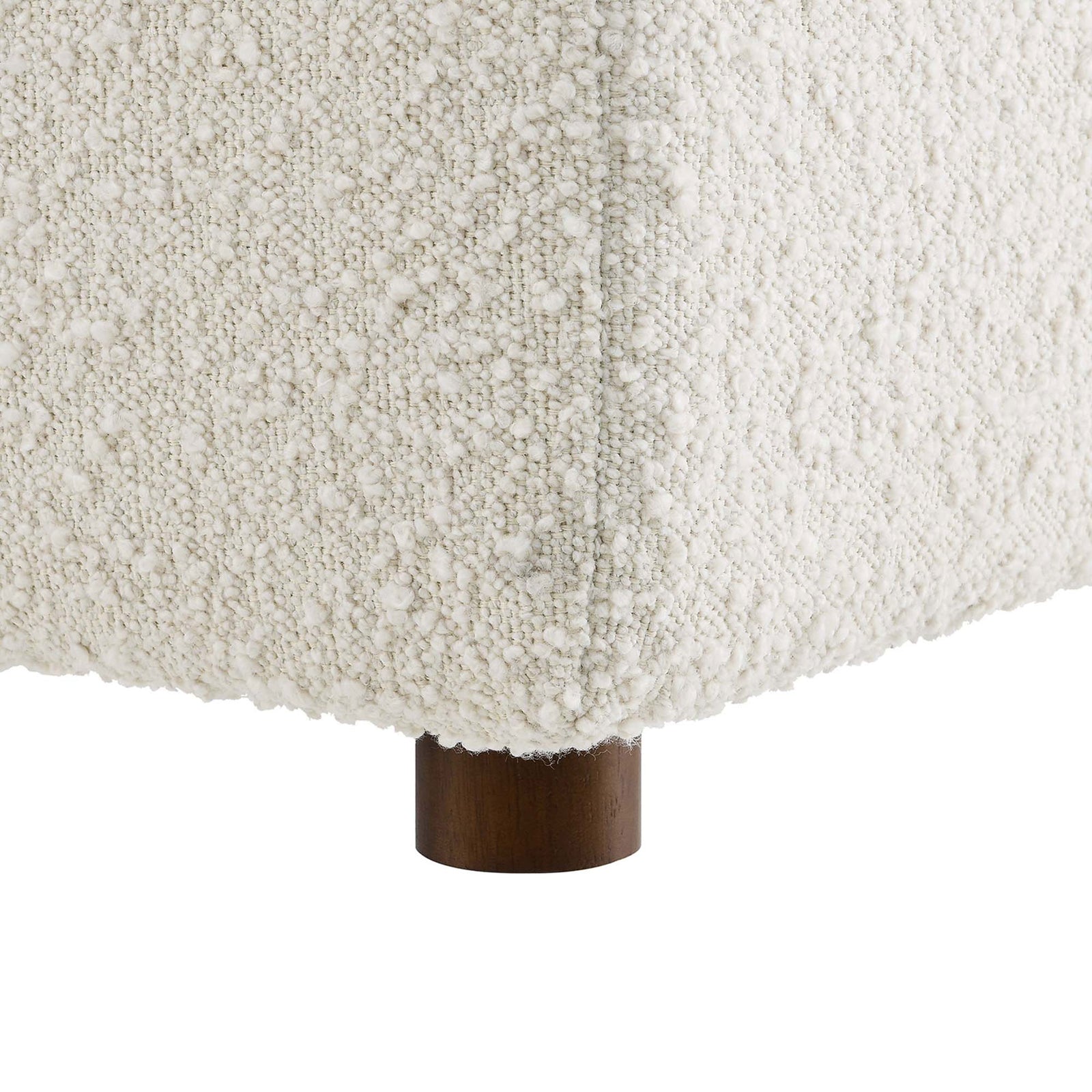 Detail of the boucle texture and round wooden foot of the ivory Commix ottoman. || EEI-6258-IVO || leg_studio