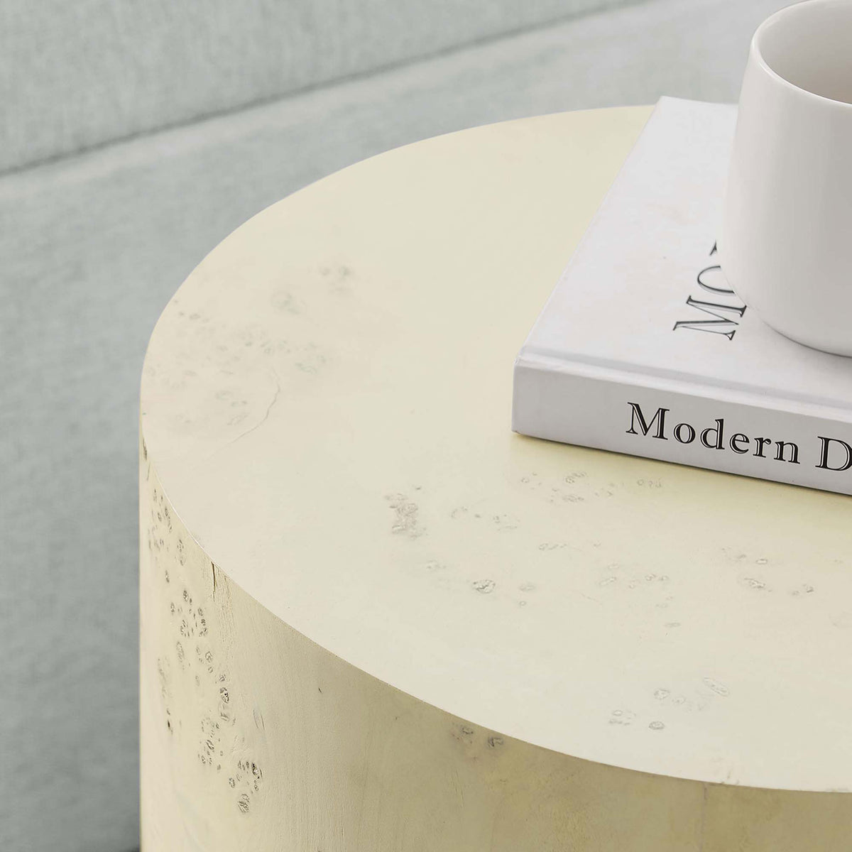 Styled tabletop scene with the bleached burl side table holding a mug and book beside a soft sofa || EEI-6271-BLB || detail_room