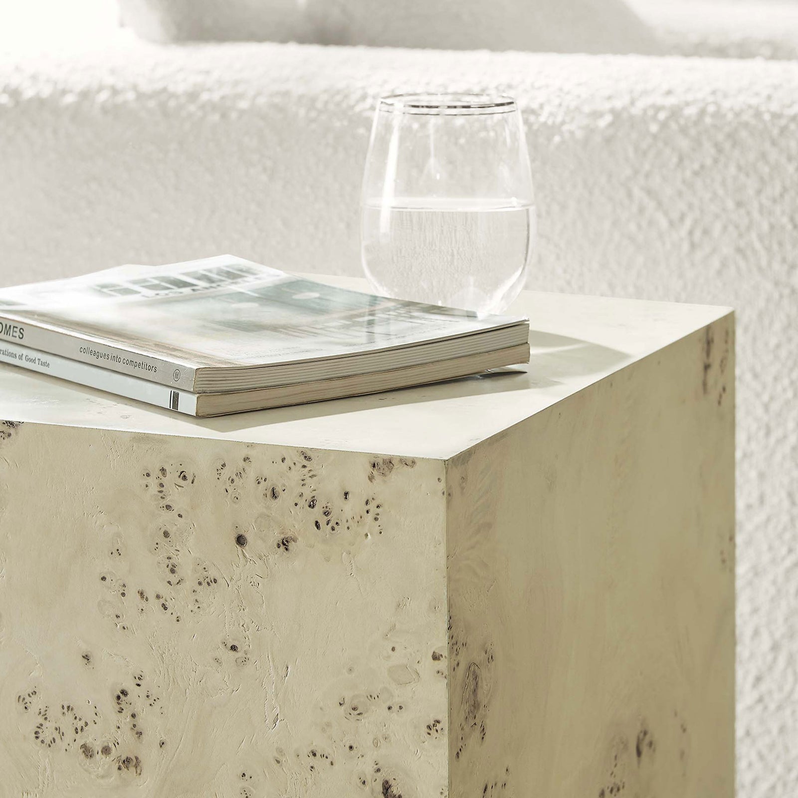 Styled burl cube table holds a magazine and glass, adding organic texture beside a plush sofa || EEI-6273-BLB || front_angle_room