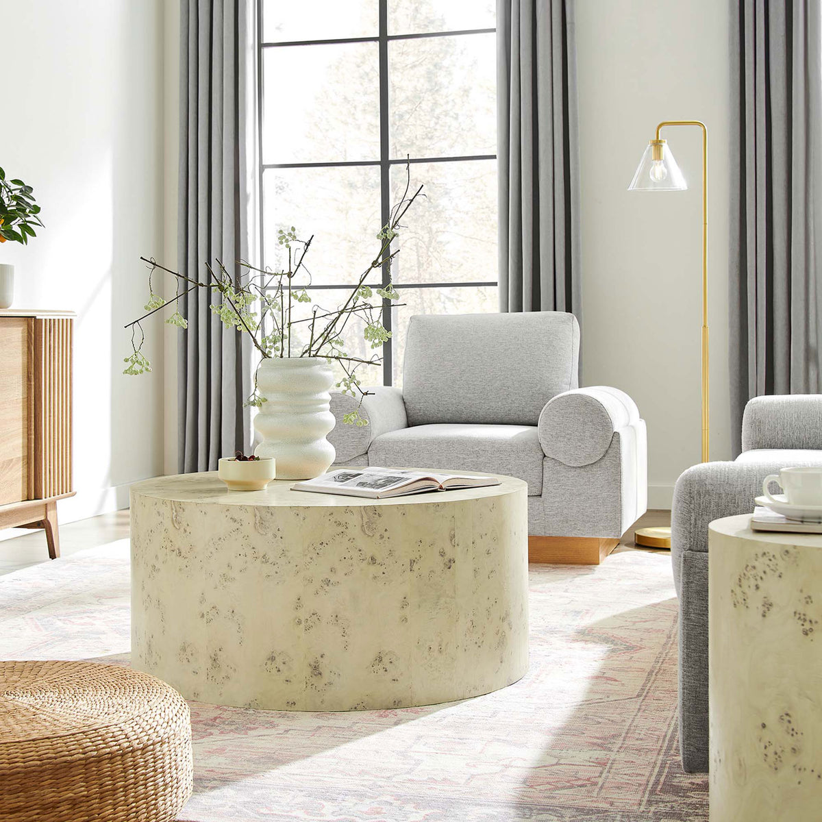 Statement-making round coffee table anchors the room with modern simplicity and organic texture || EEI-6274-BLB || front_angle_room