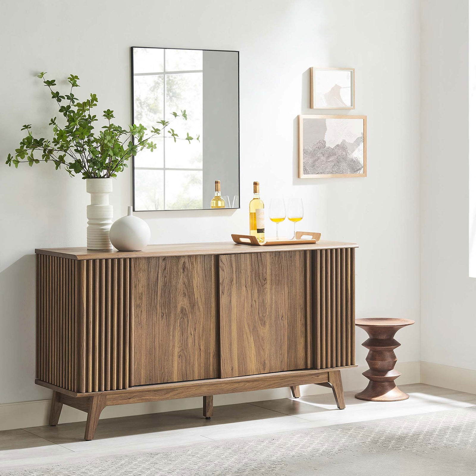 Walnut Eudora sideboard styled with decor in a bright room, offering elegant storage and display space. || EEI-6278-WAL || front_angle_room