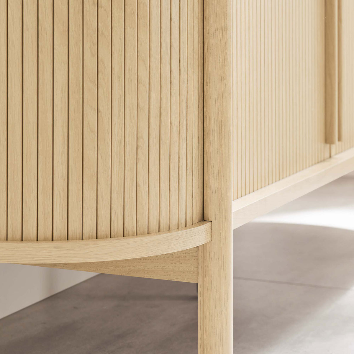 Sideboard's rounded leg and raised base keep the oak cabinet feeling light while making floors easy to clean. || EEI-6309-OAK || leg_room