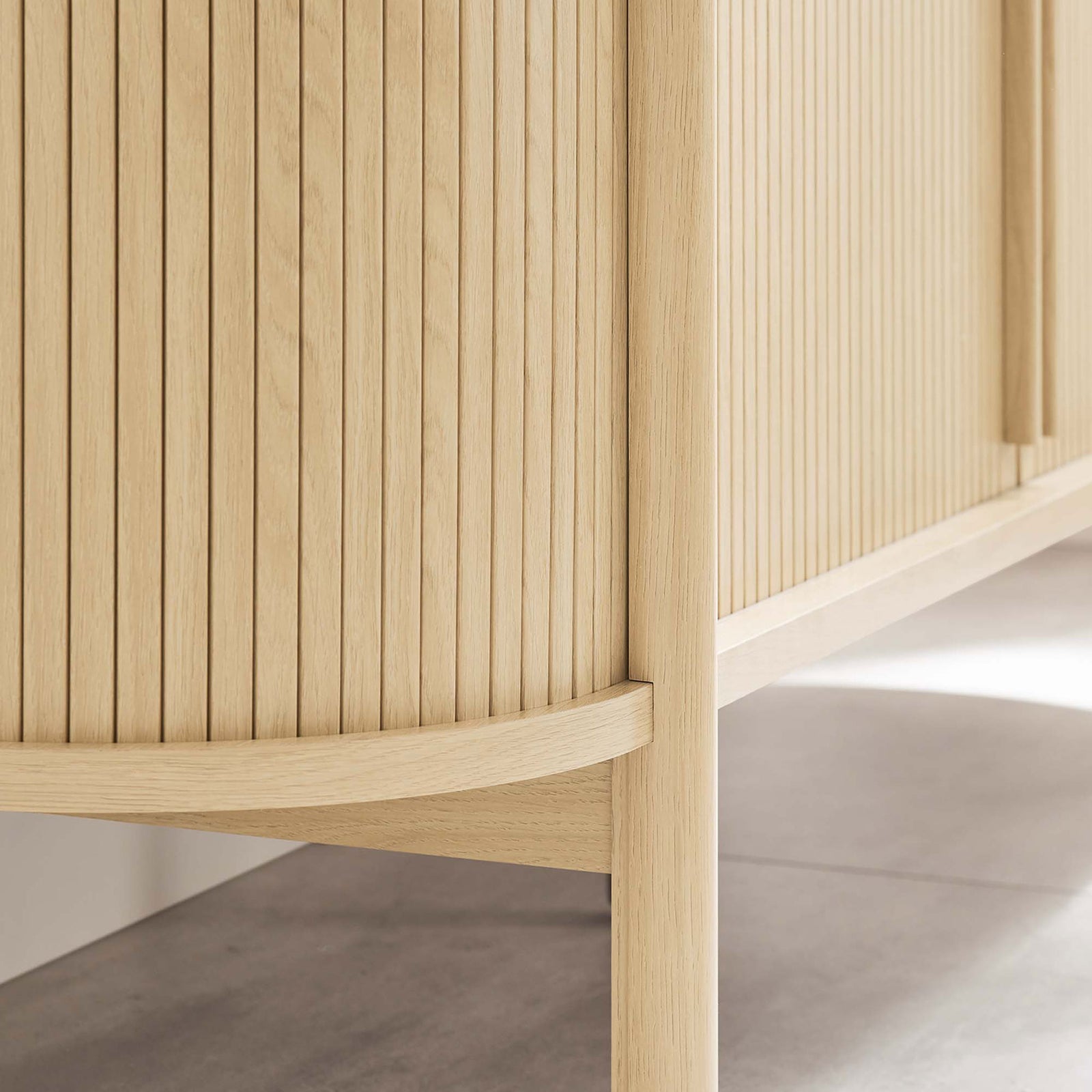 Sideboard's rounded leg and raised base keep the oak cabinet feeling light while making floors easy to clean. || EEI-6309-OAK || leg_room