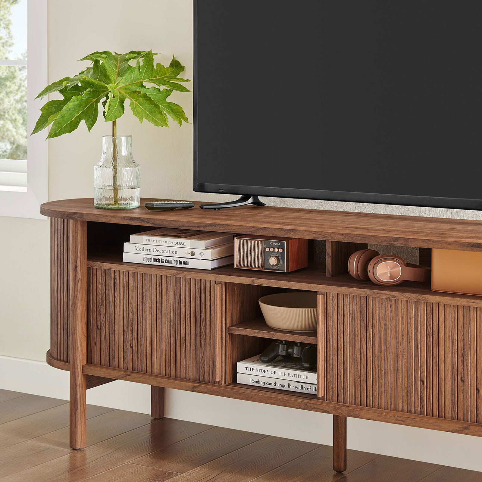 Walnut TV cabinet shelf styled with books, decor, and media devices for everyday organization. || EEI-6310-WAL || detail_room
