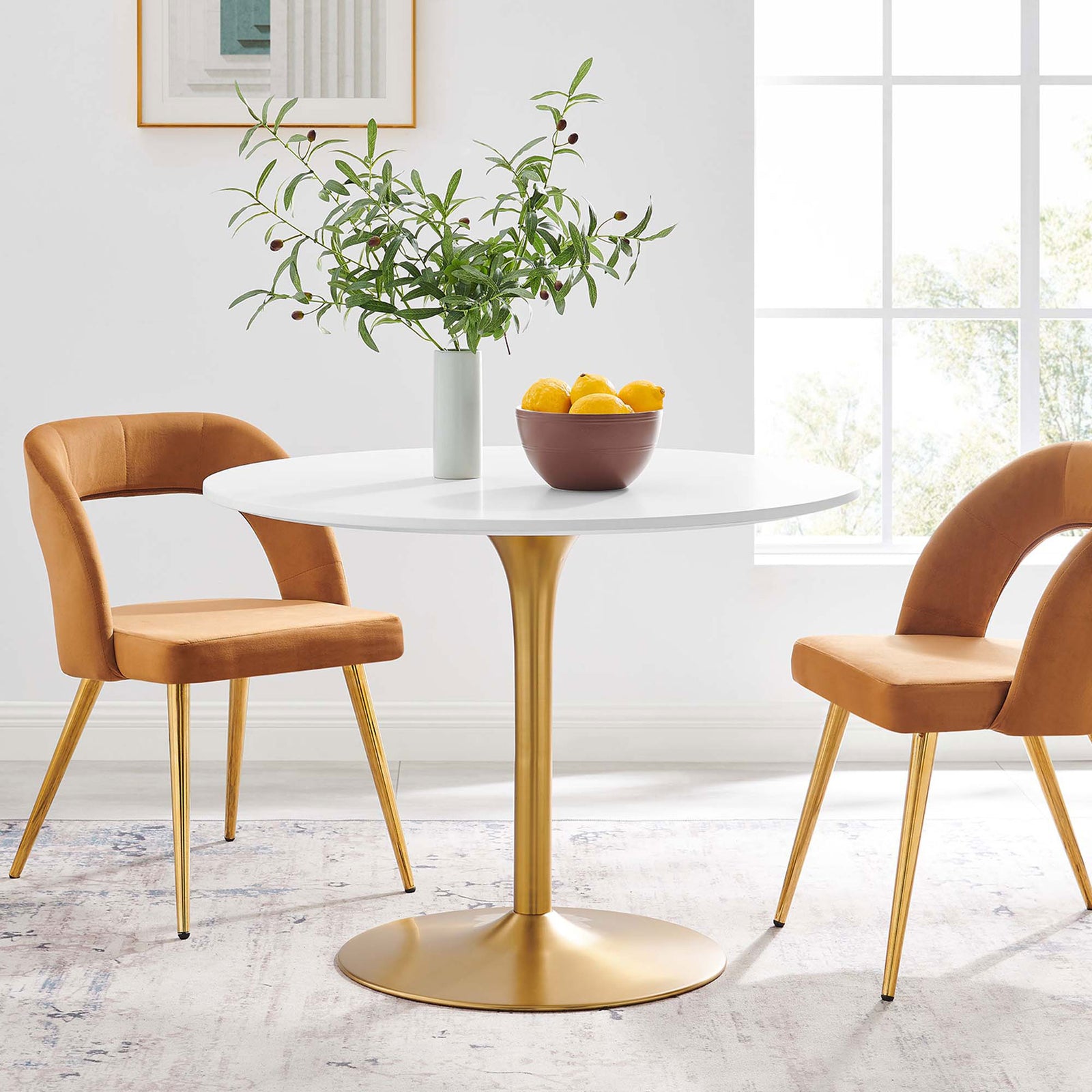 Round white dining table with gold pedestal base styled in a bright, contemporary breakfast nook || EEI-6313-WHI-GLD || front_angle_room