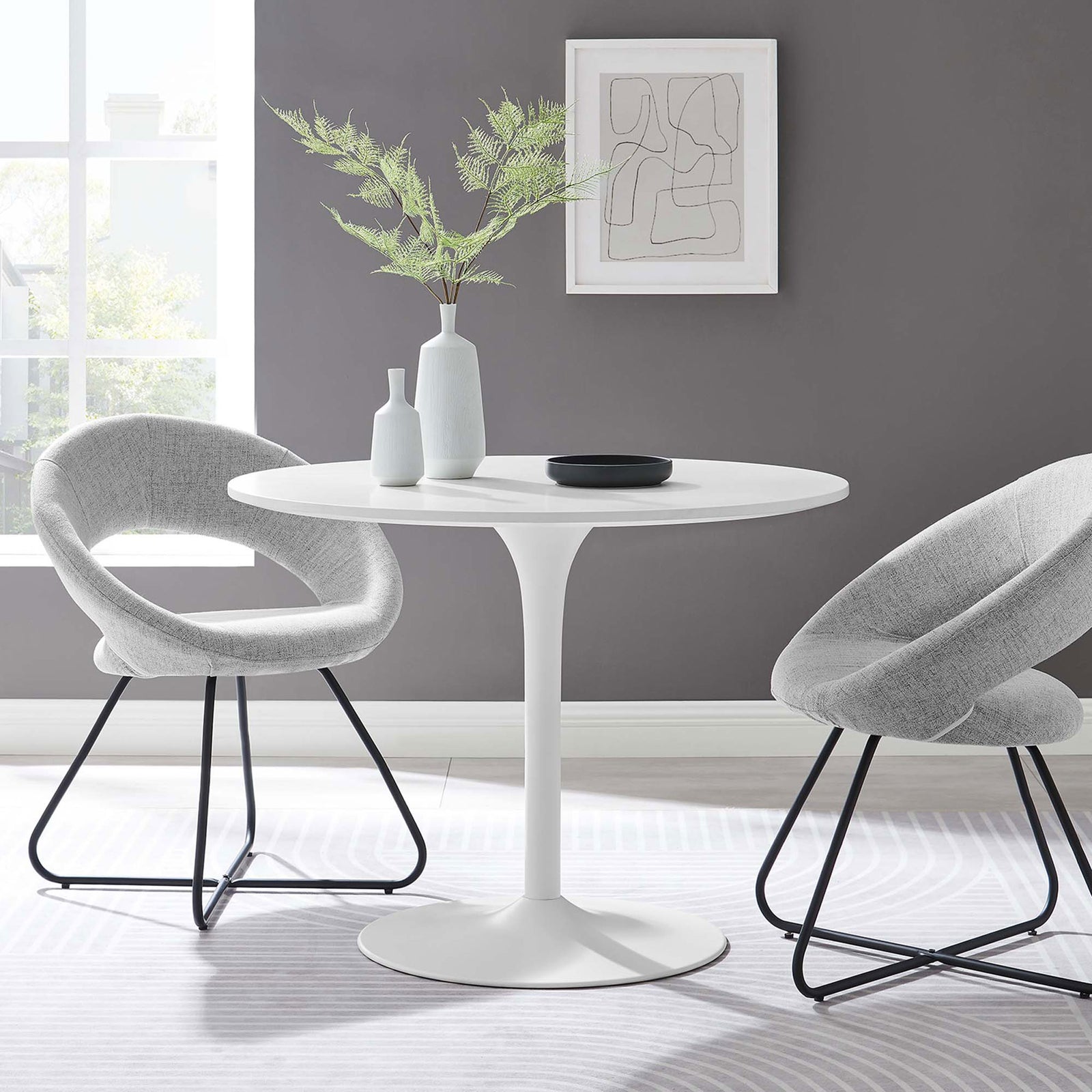 White round pedestal dining table styled in a modern dining nook with gray chairs and airy decor || EEI-6313-WHI-WHI || front_room