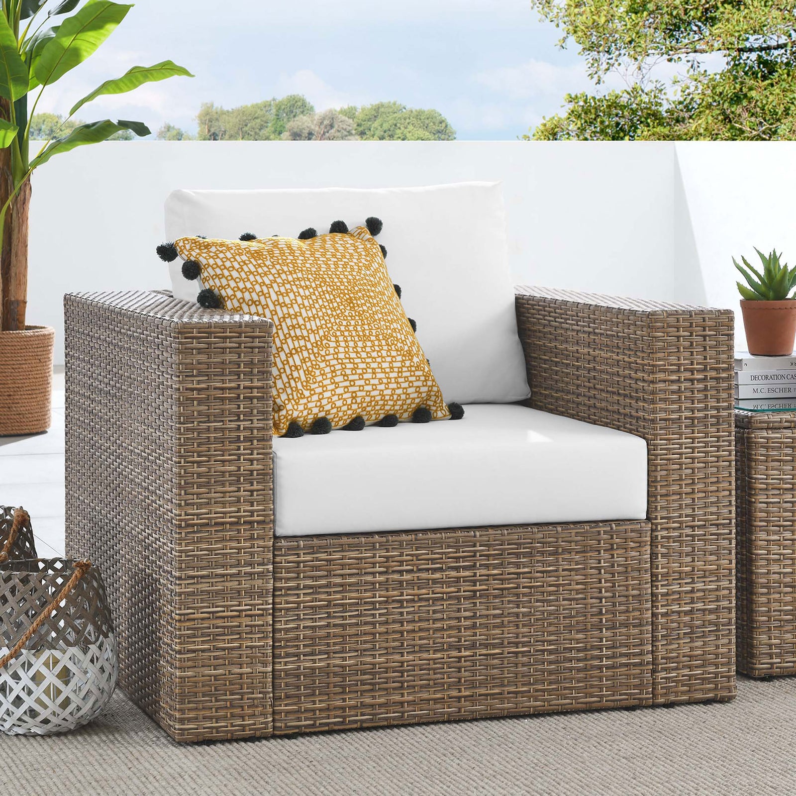Cappuccino wicker patio armchair with white cushions styled on a terrace with pillow and decor accents || EEI-6326-CAP-WHI || front_angle_room