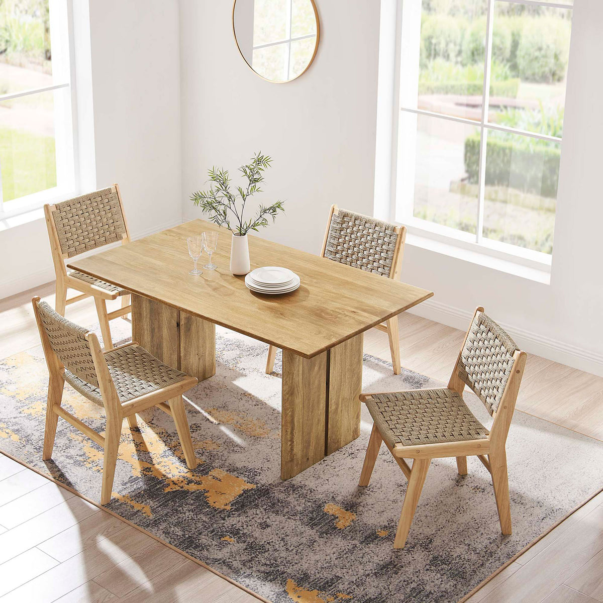 60 inch oak dining table arranged on a patterned rug with four coordinating woven chairs. || EEI-6338-OAK || top_angle_room