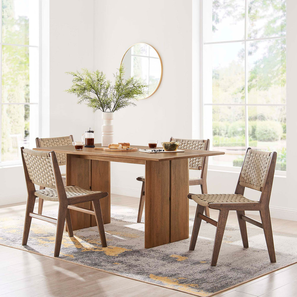 Amistad 60 inch dining table styled in a bright dining room with four woven side chairs || EEI-6338-WAL || front_room