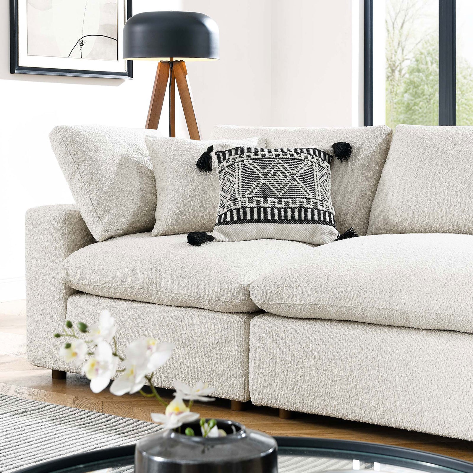 Cozy ivory boucle sofa cushions layered with a black and white tasseled accent pillow in a bright living space || EEI-6364-IVO || detail_room