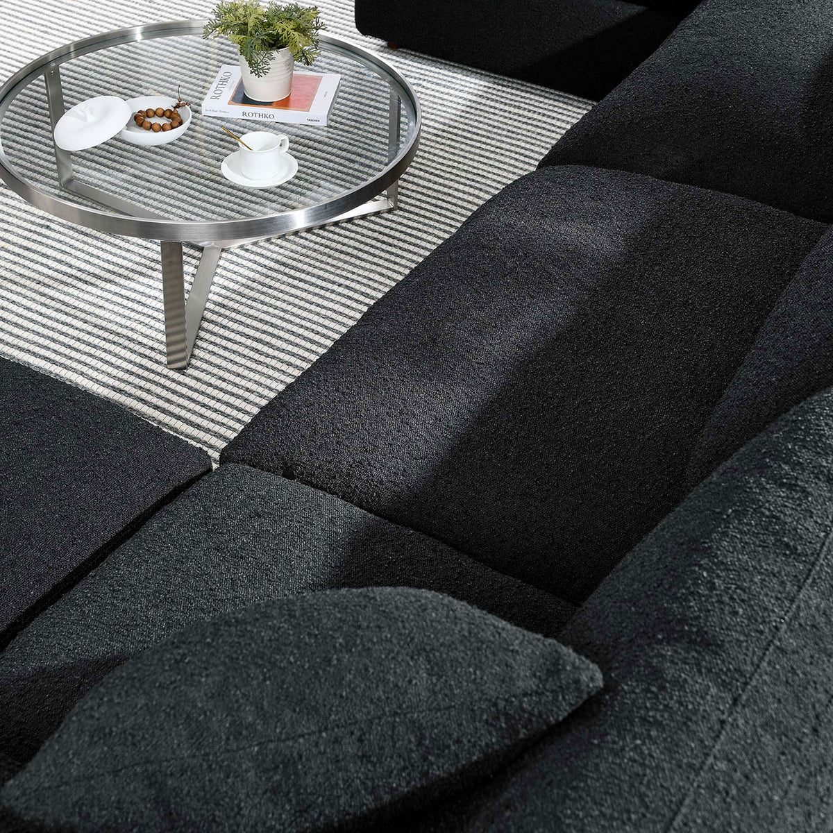 Close-up of black boucle cushions and pillows showcasing the Commix sectional s soft, textured upholstery || EEI-6366-BLK || detail_room