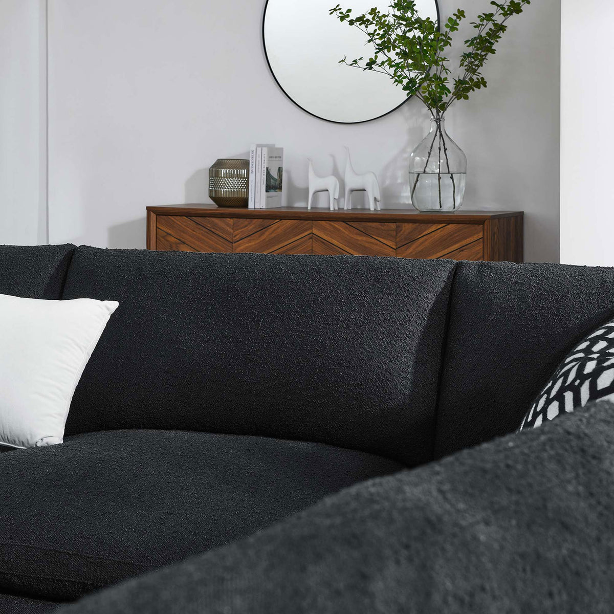 Black boucle sectional cushions styled with patterned and solid pillows in a bright modern living room || EEI-6367-BLK || detail_room