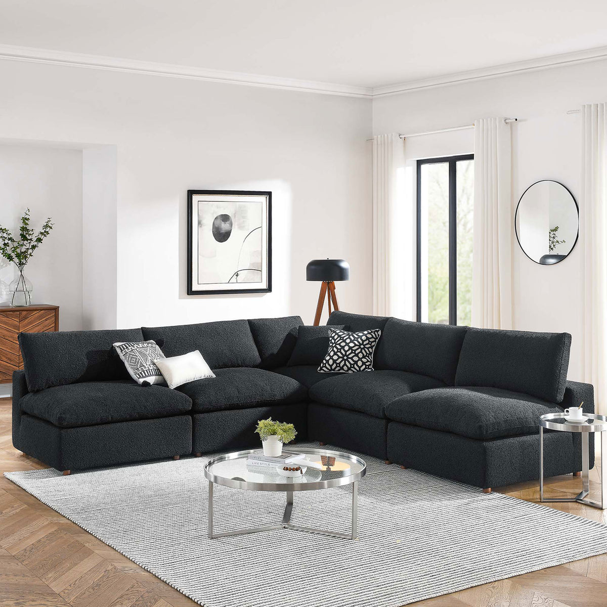 Black boucle sectional sofa anchoring a spacious living room with light walls, wood floors, and modern decor || EEI-6367-BLK || front_angle_room