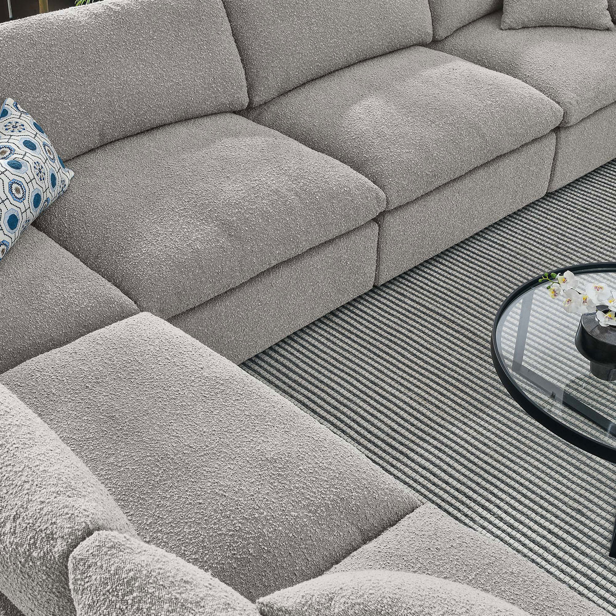 Cozy corner of the light gray boucle sectional styled with a striped rug and round glass coffee table || EEI-6369-LGR || detail_room