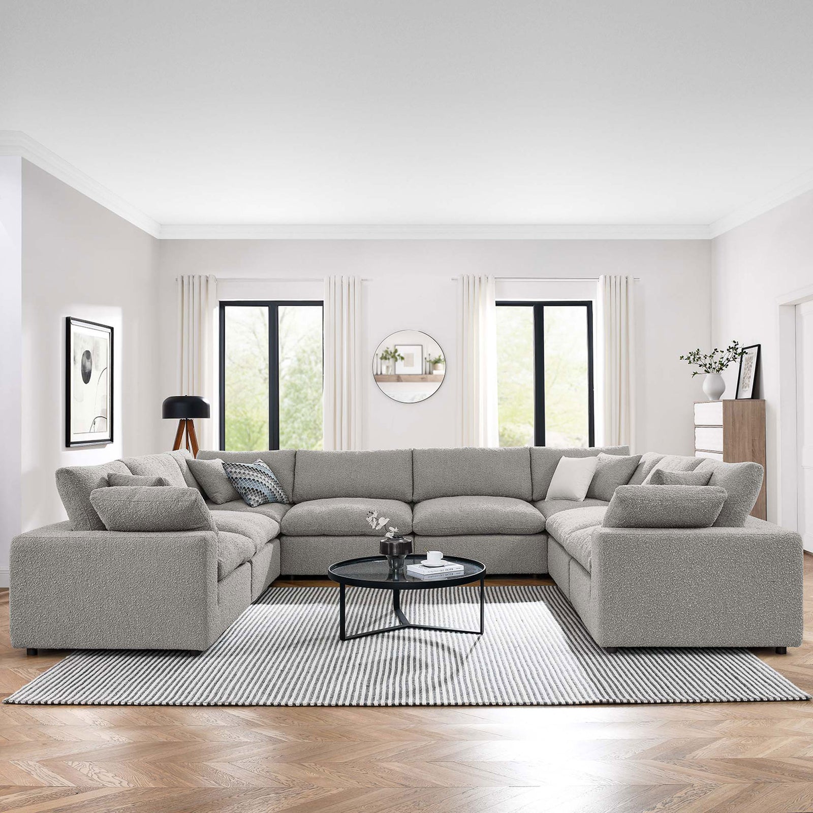 Light gray boucle U-shaped sectional anchoring a bright modern living room with striped rug and round nesting tables || EEI-6371-LGR || front_angle_room