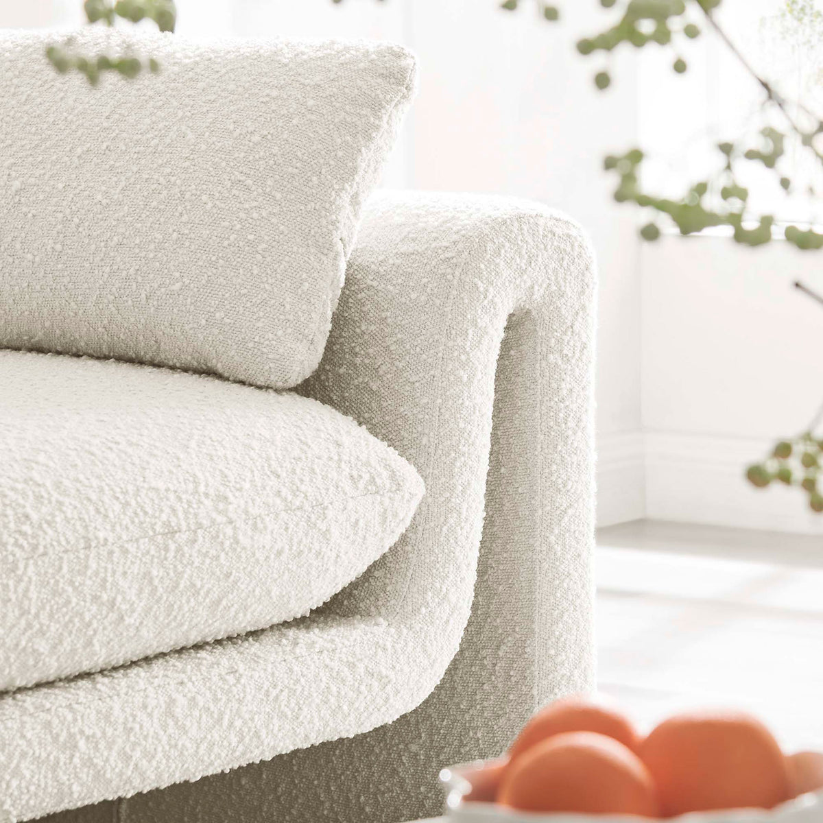 Ivory boucle arm and pillow of the Waverly sofa styled in a bright, airy living room || EEI-6381-IVO || detail_room