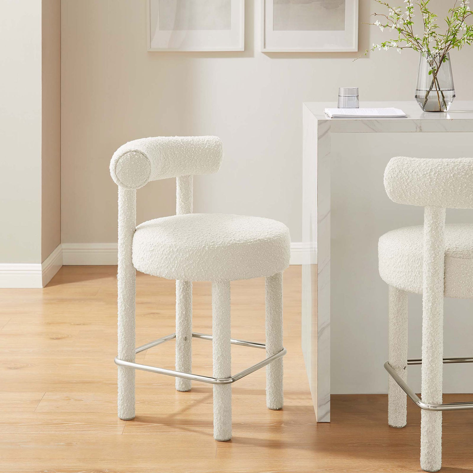 Ivory boucle counter stool styled at a marble island with sleek silver footrest || EEI-6383-IVO-SLV || front_angle_room