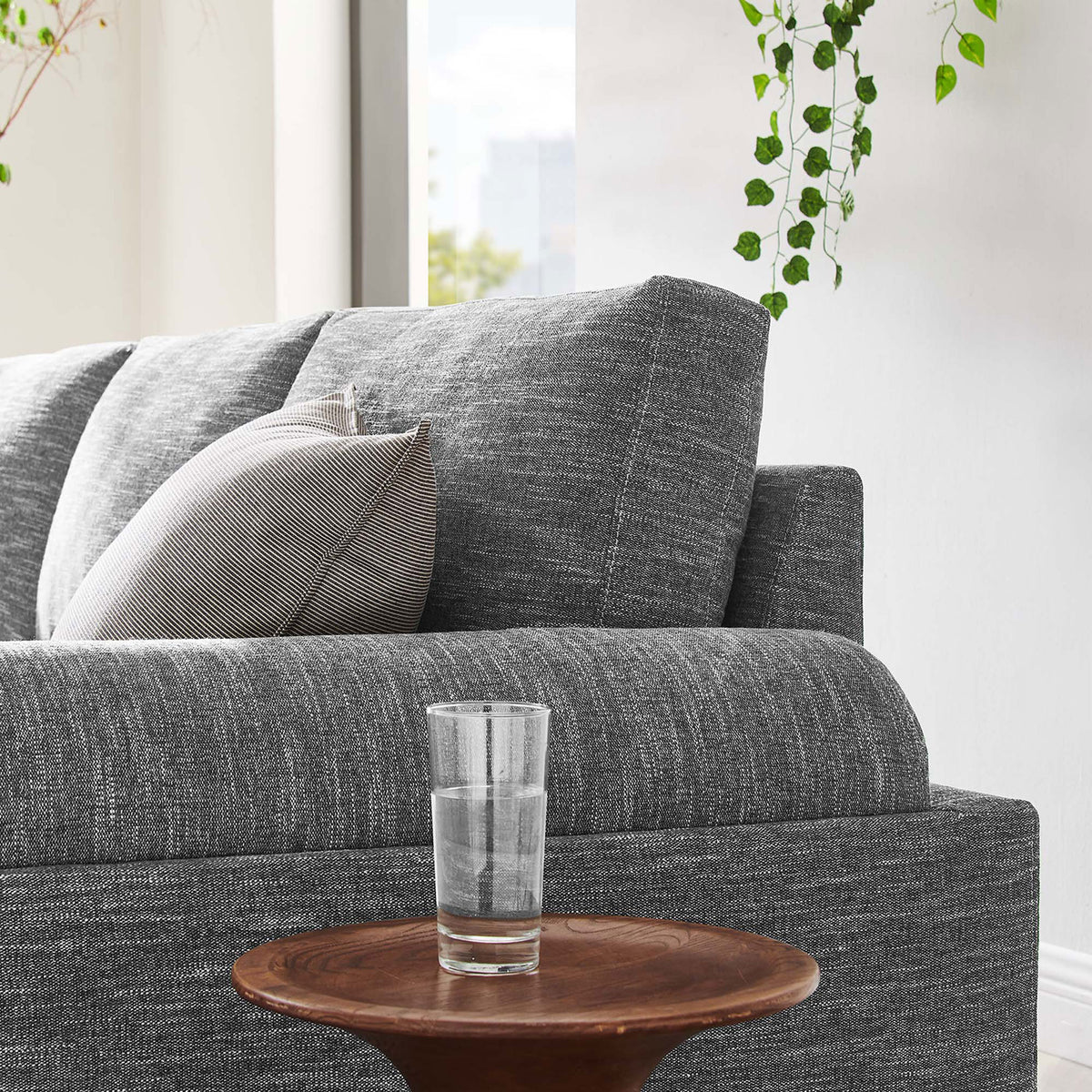 Gray upholstered sofa styled in a bright living room with layered cushions and soft textured fabric || EEI-6401-GRY || detail_room