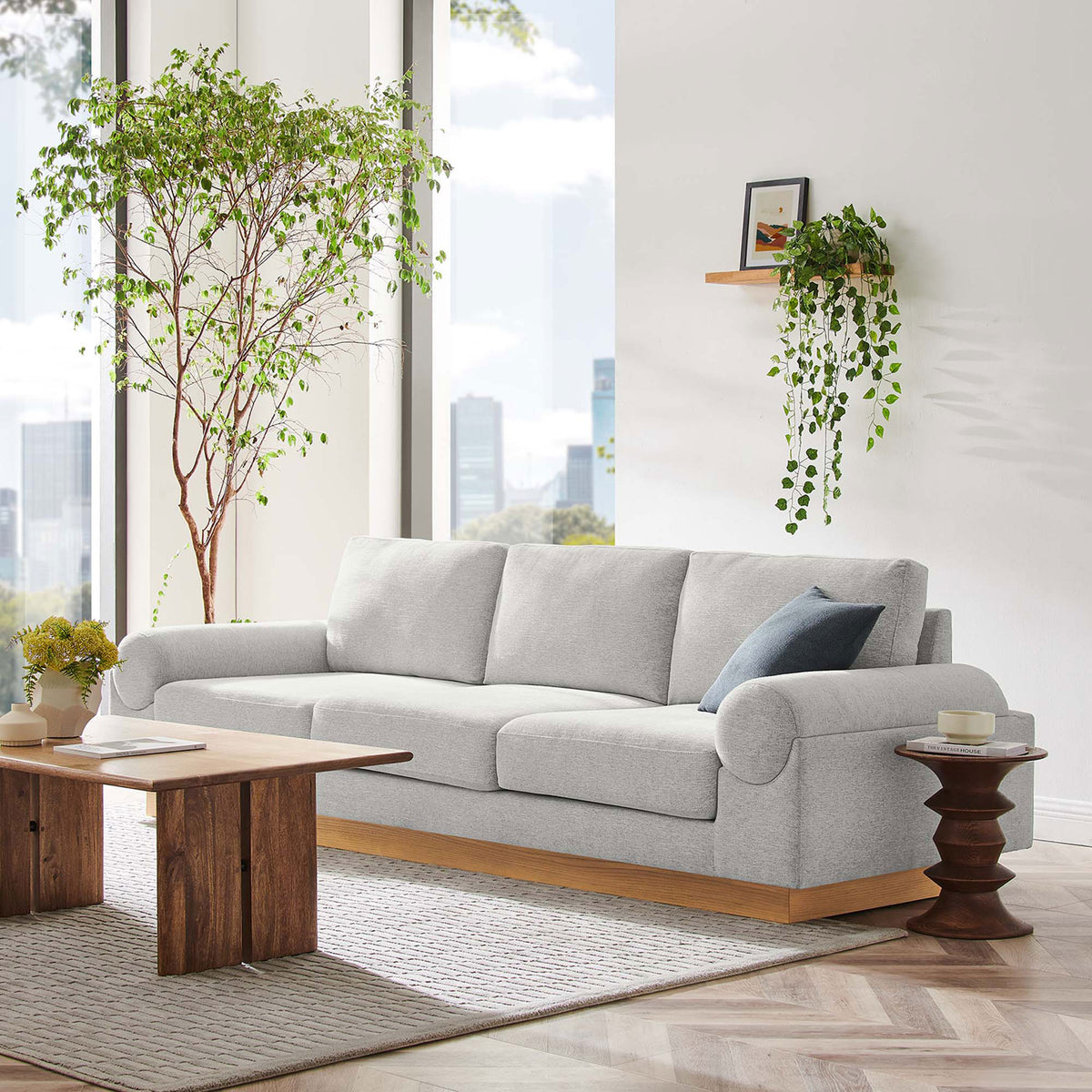 Light gray Oasis sofa on wood base anchoring a modern living room with warm natural textures || EEI-6401-LGR || front_angle_room