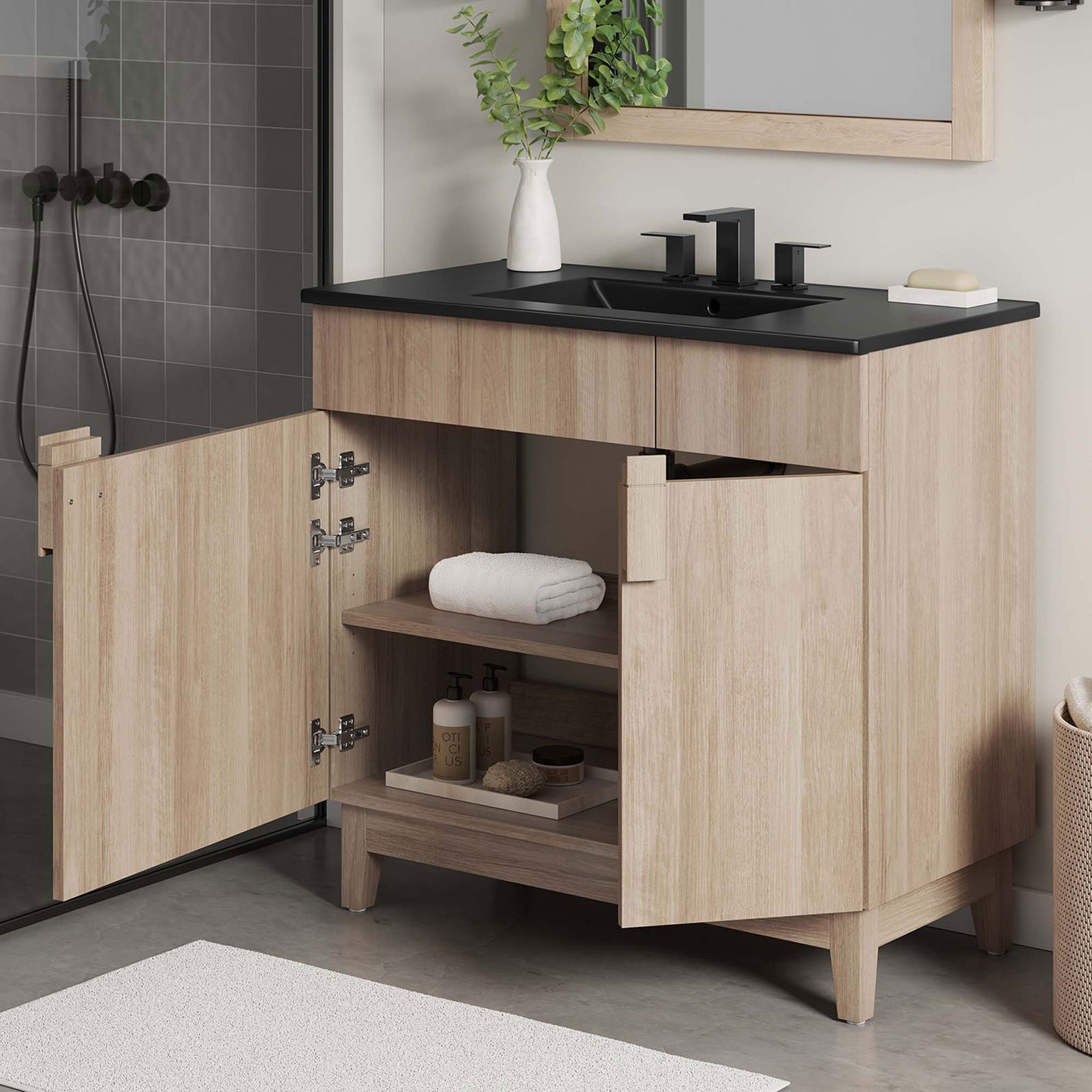 Open doors display roomy shelves for towels and toiletries, plus a plumbing cutout for easy access. || EEI-6485-BLK-OAK || front_angle_open_room