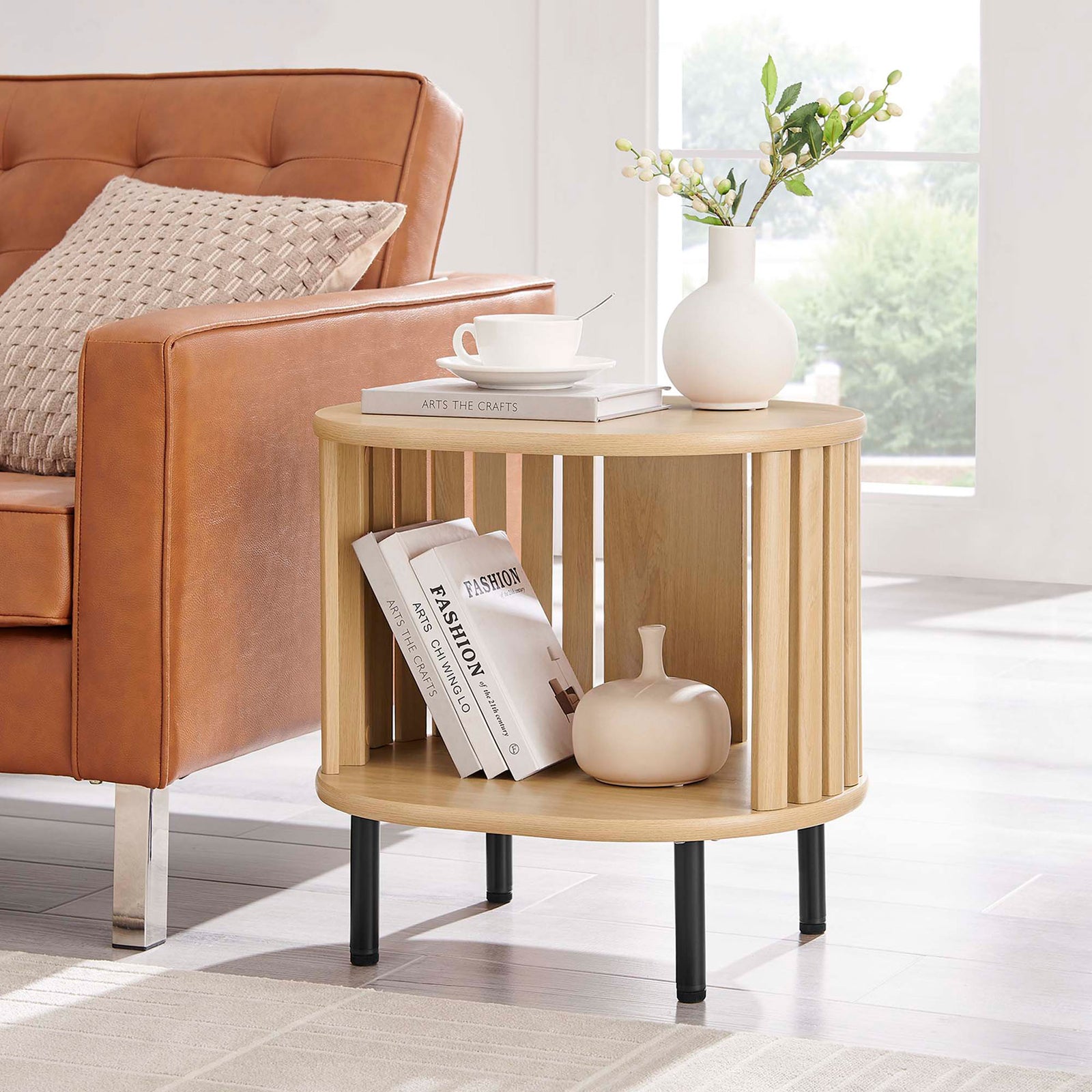 Oak side table styled beside a sofa with decor and books on the open shelf and tabletop || EEI-6523-OAK || front_angle_room