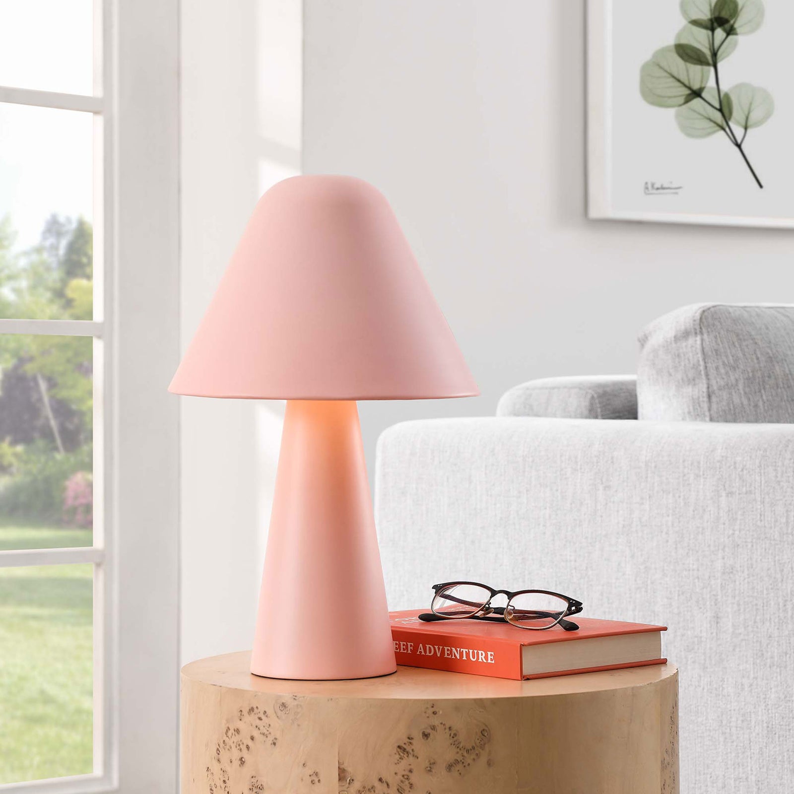 Illuminated pink mushroom table lamp adds a cozy glow next to a modern sofa and window. || EEI-6529-PNK || front_angle_on_room