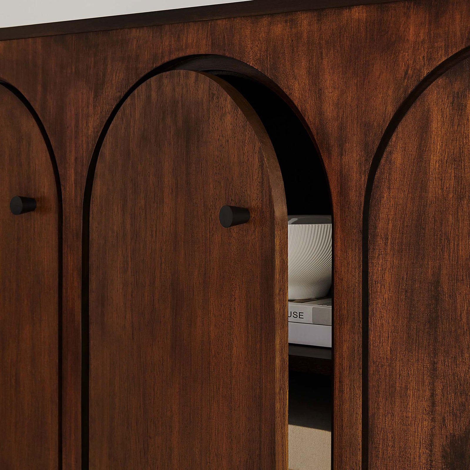 Appia sideboard door partially open to reveal neatly organized shelves with bowls and books. || EEI-6536-WAL || storage_open_room