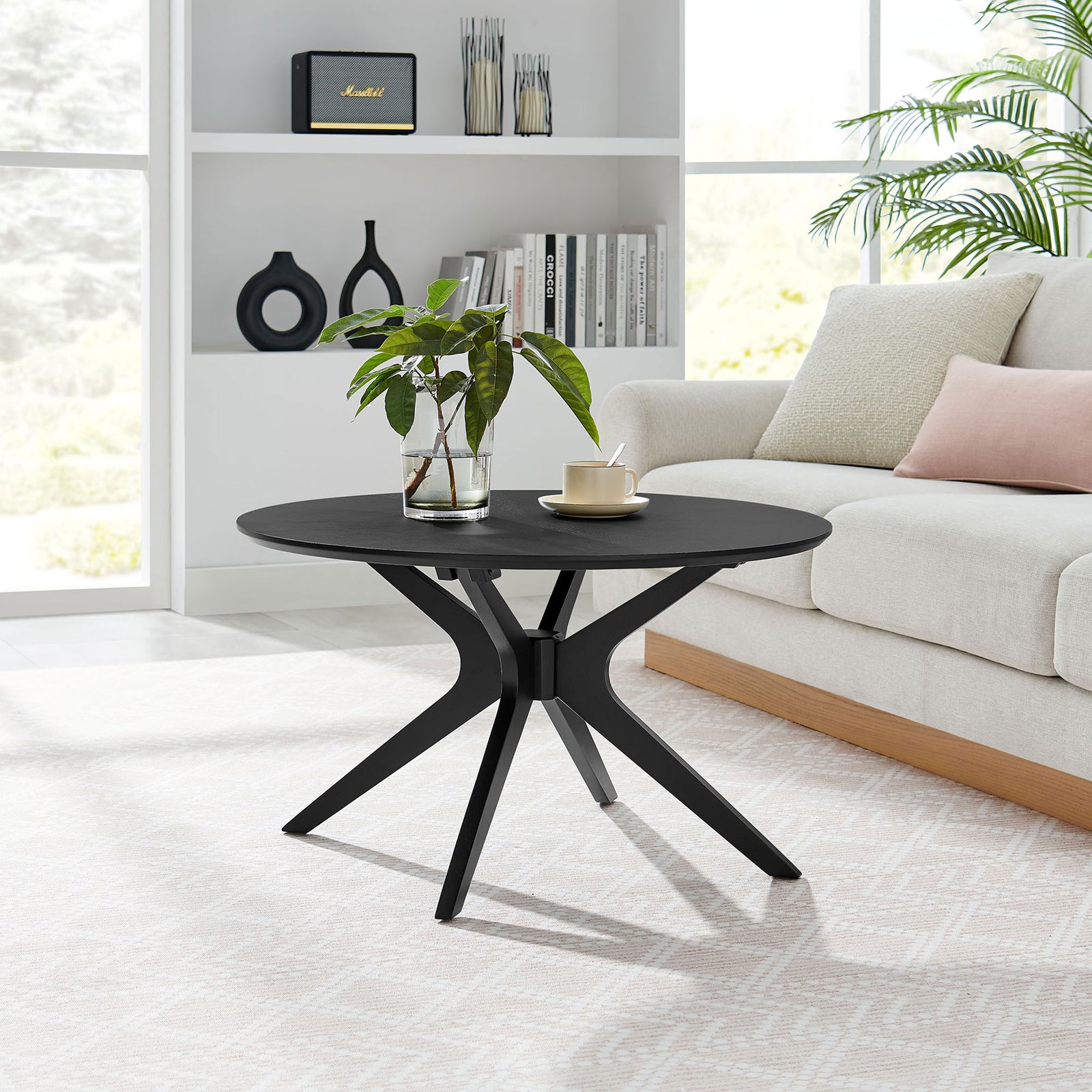 Mid-century round coffee table anchors the living room with a clean silhouette and airy base || EEI-6557-BLK || front_angle_room