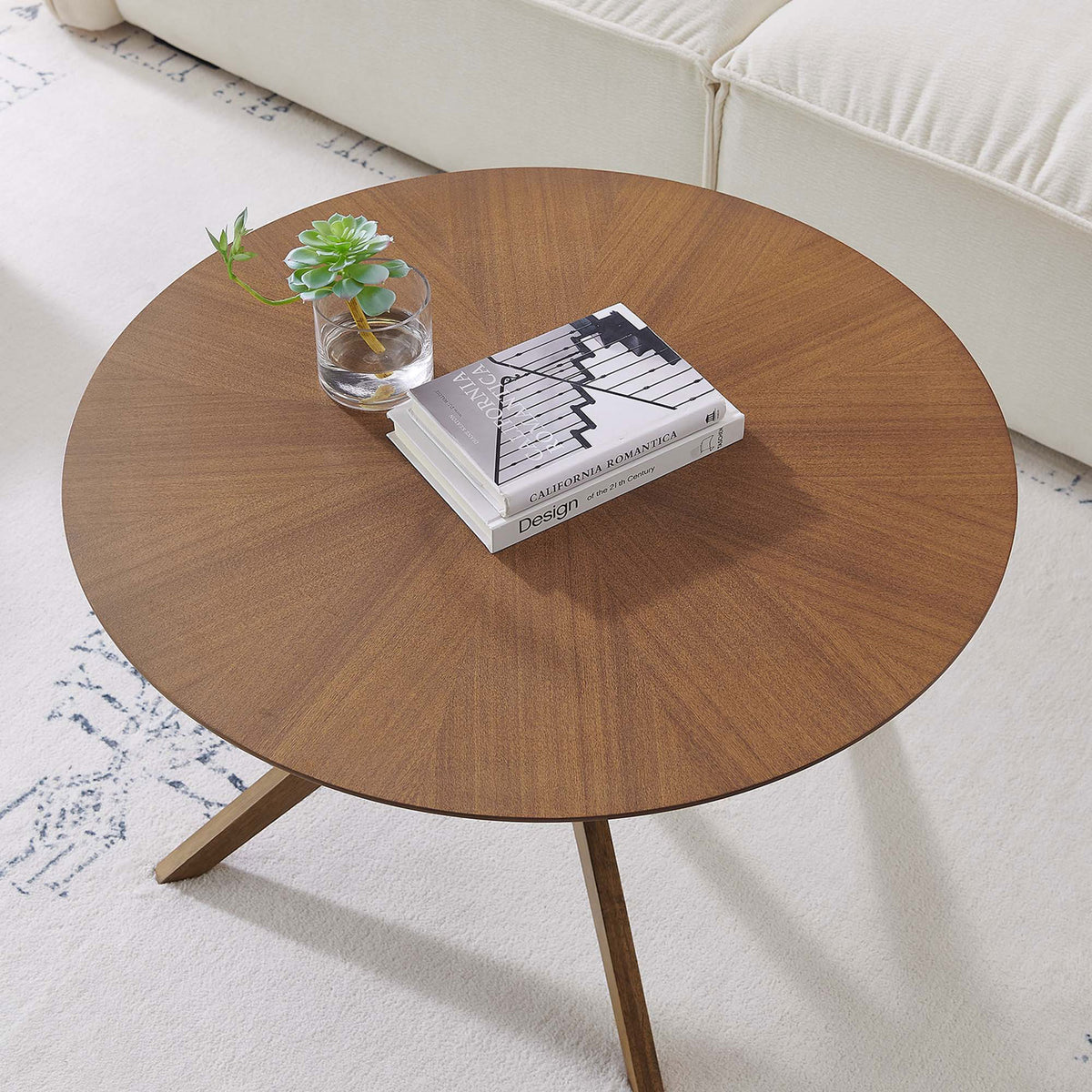 Styled tabletop with books and decor showcases the warm walnut finish in a modern living room. || EEI-6557-WAL || top_room
