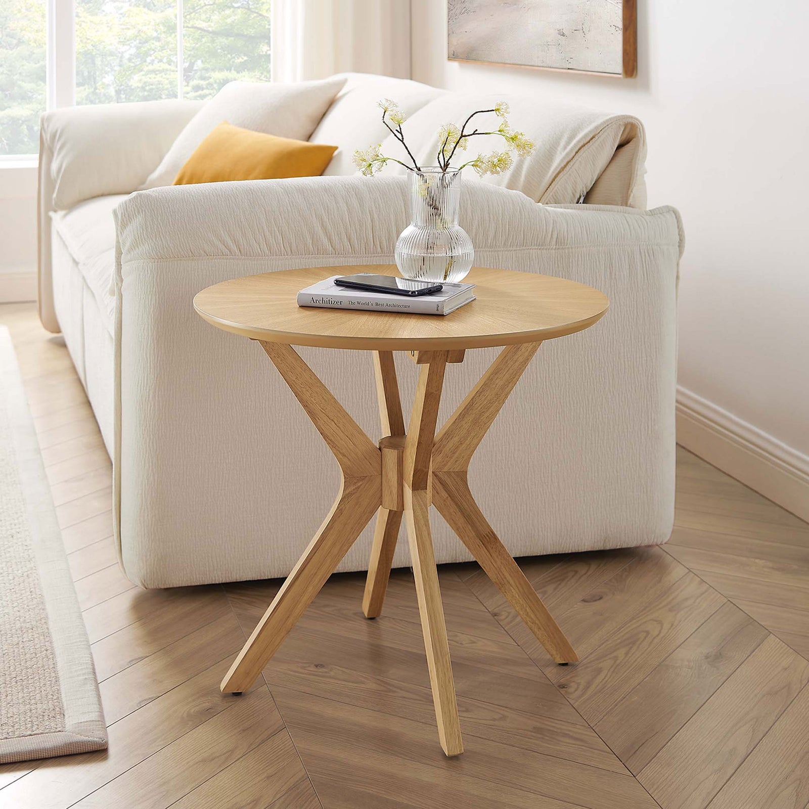 Oak round side table beside a cream sofa, adding warm mid-century charm to the living room. || EEI-6558-OAK || front_angle_room