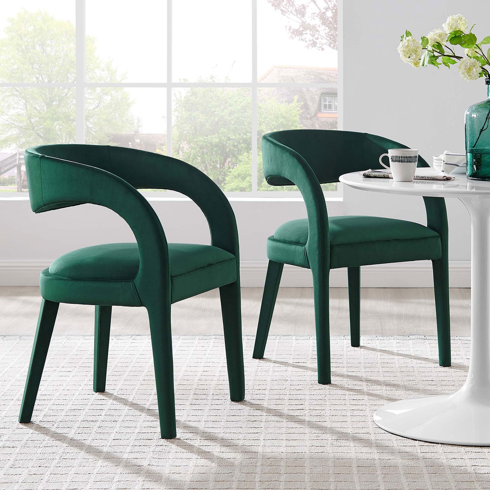 Set of two green velvet dining chairs surrounding a white pedestal table in a contemporary dining space || EEI-6563-GRN || front_angle_multi_room