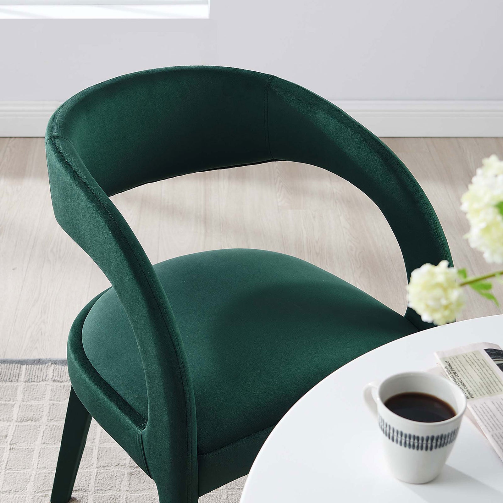 Green velvet dining chair at a white dining table, adding a rich pop of color to a bright modern room || EEI-6563-GRN || detail_room