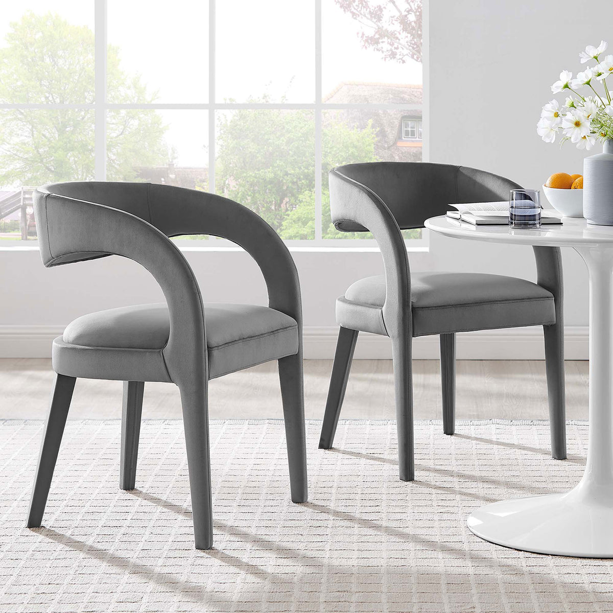 Set of two gray velvet dining chairs around a white pedestal table creating a cozy, contemporary dining space || EEI-6563-GRY || front_angle_multi_room
