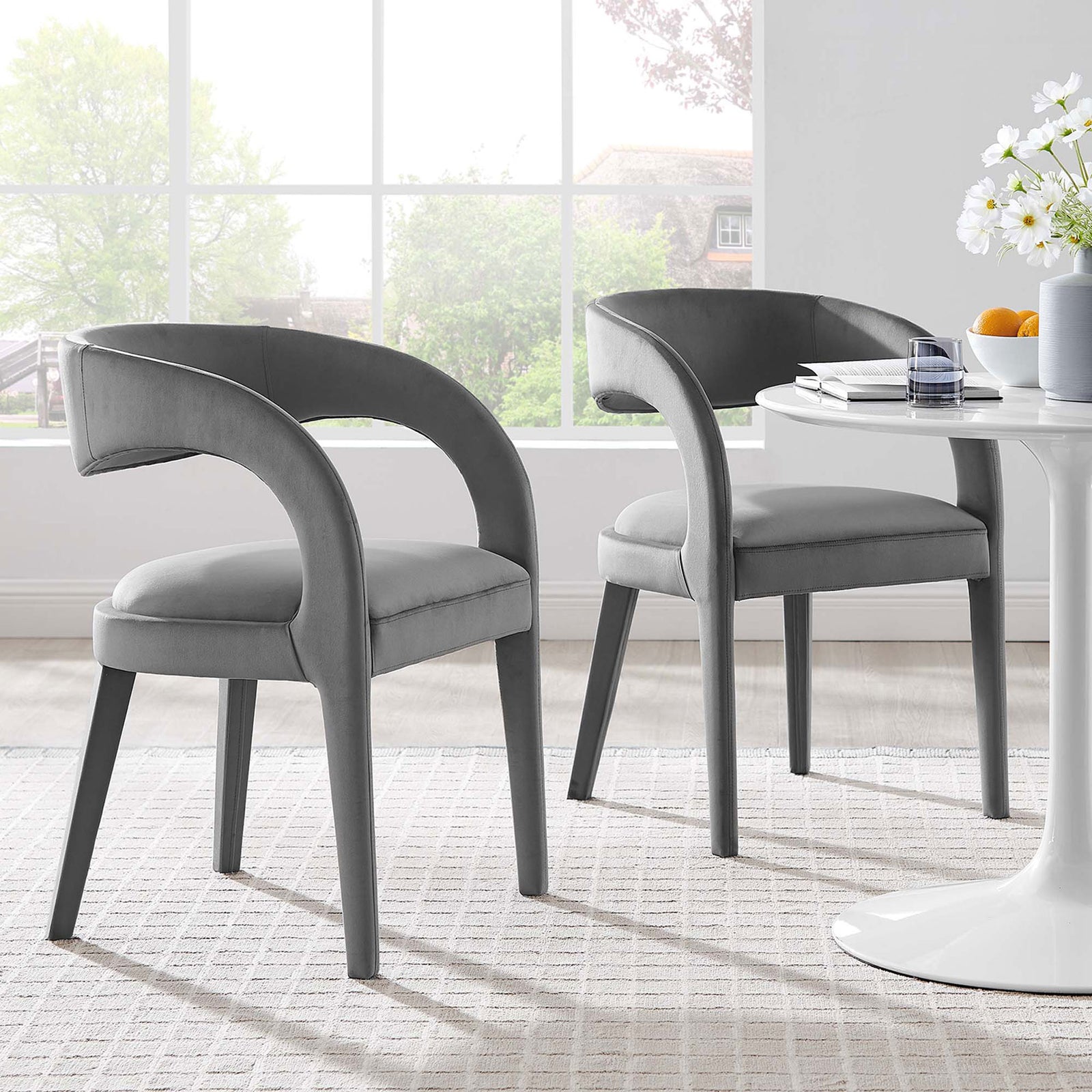 Set of two gray velvet dining chairs around a white pedestal table creating a cozy, contemporary dining space || EEI-6563-GRY || front_angle_multi_room