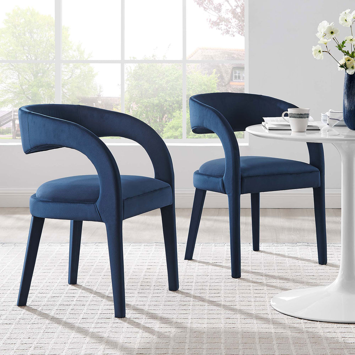 Set of two midnight blue velvet dining chairs bringing soft texture and sculptural lines to the dining room || EEI-6563-MID || front_angle_multi_room