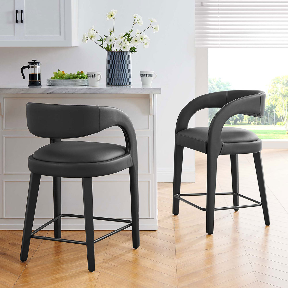 Pair of counter stools bring modern comfort to a bright kitchen with padded seats and curved backs || EEI-6564-BLK-BLK || front_angle_multi_room