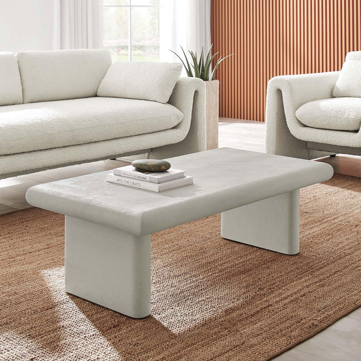 Modern white coffee table grounds the space with rounded edges and a stone-like texture. || EEI-6578-WHI || front_angle_room