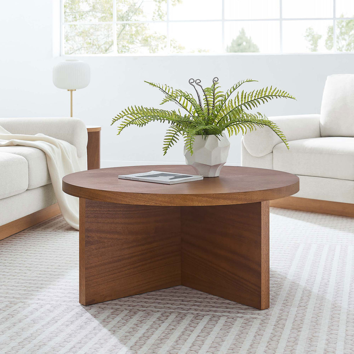 Modern round coffee table anchors the room with its sculptural X-base and warm walnut tone || EEI-6580-WAL || front_angle_room