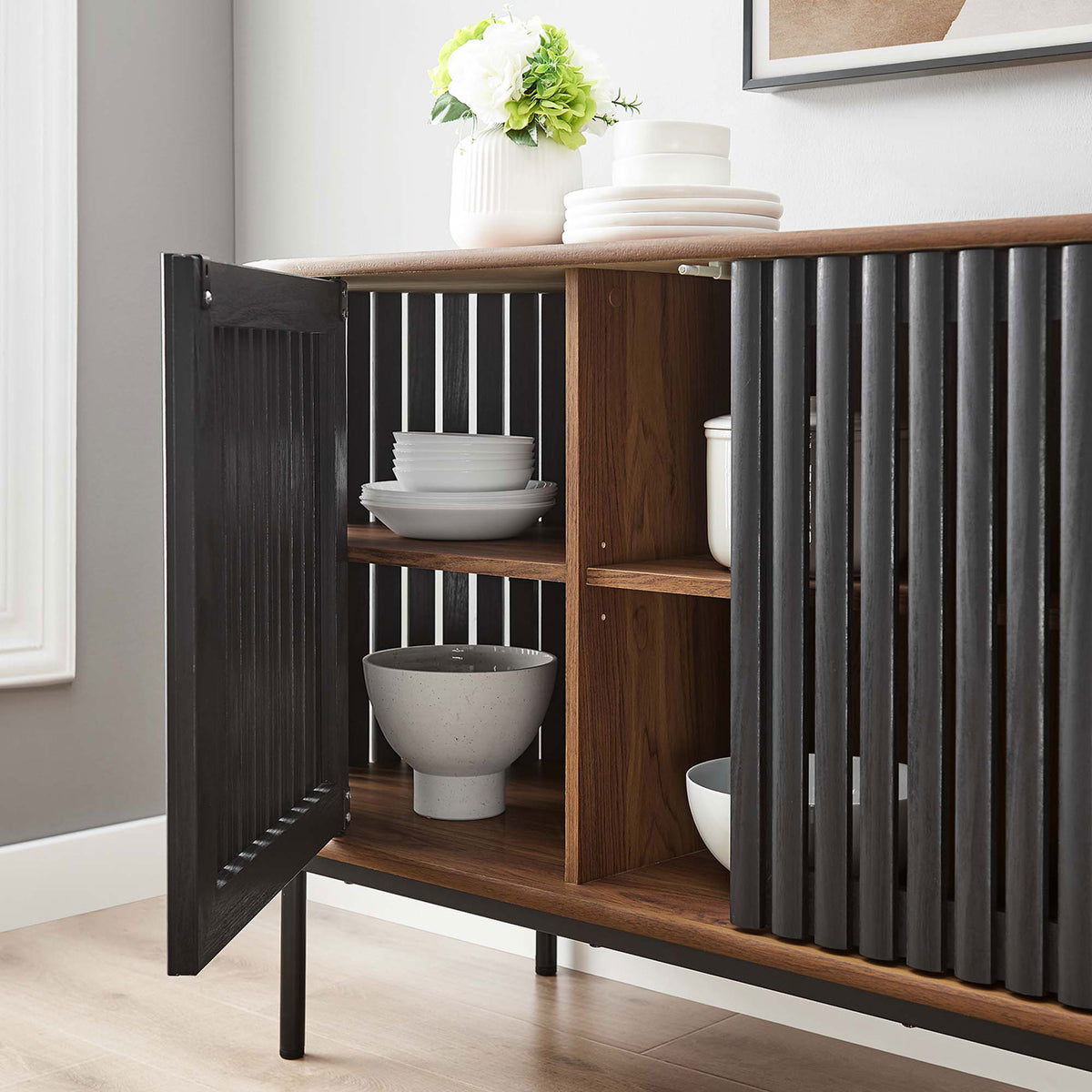 Sideboard in a modern dining space with open cabinet displaying neatly organized serveware. || EEI-6590-WAL-BLK || storage_open_room