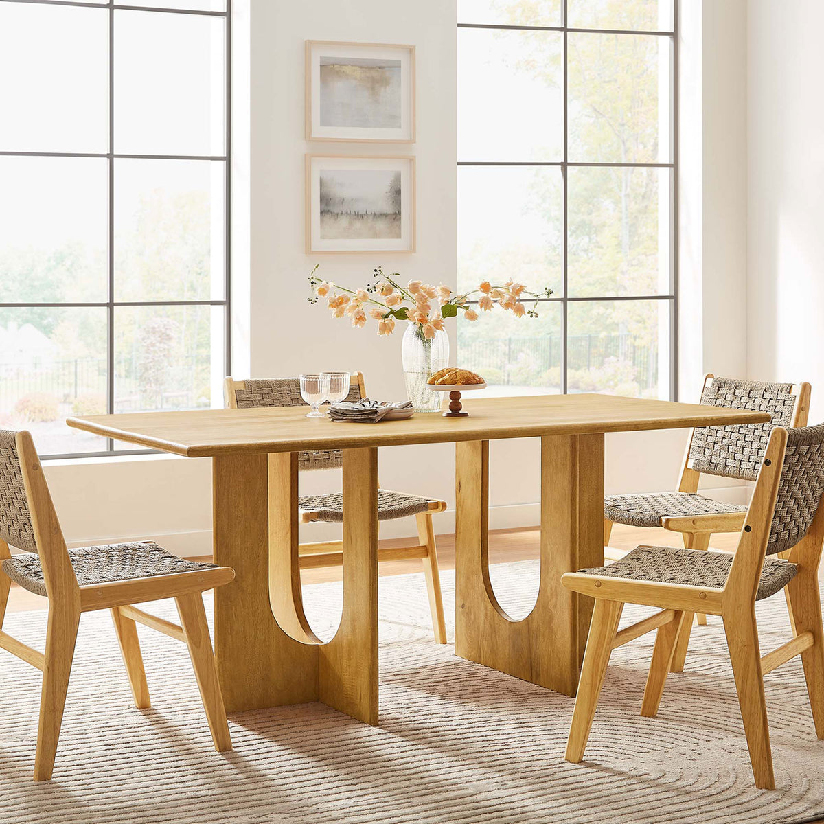 Oak dining table centerpiece in a modern dining room with woven chairs around it || EEI-6593-OAK || front_angle_room