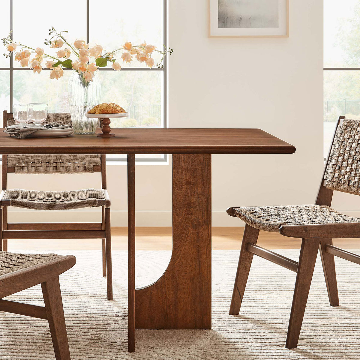 Walnut mango wood dining table styled in an airy dining room with woven chairs, fresh flowers, and soft neutral decor || EEI-6593-WAL || detail_room