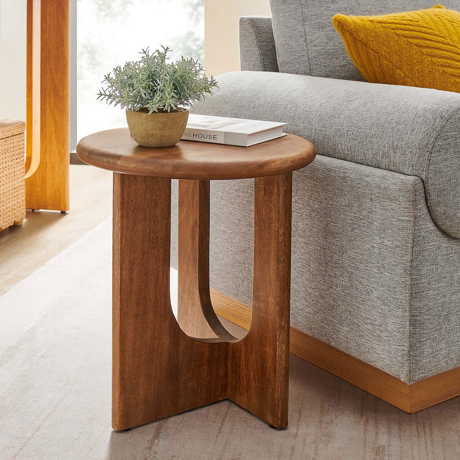 Rivian round walnut side table next to a modern sofa showcasing its compact scale in a living room || EEI-6595-WAL || front_angle_room
